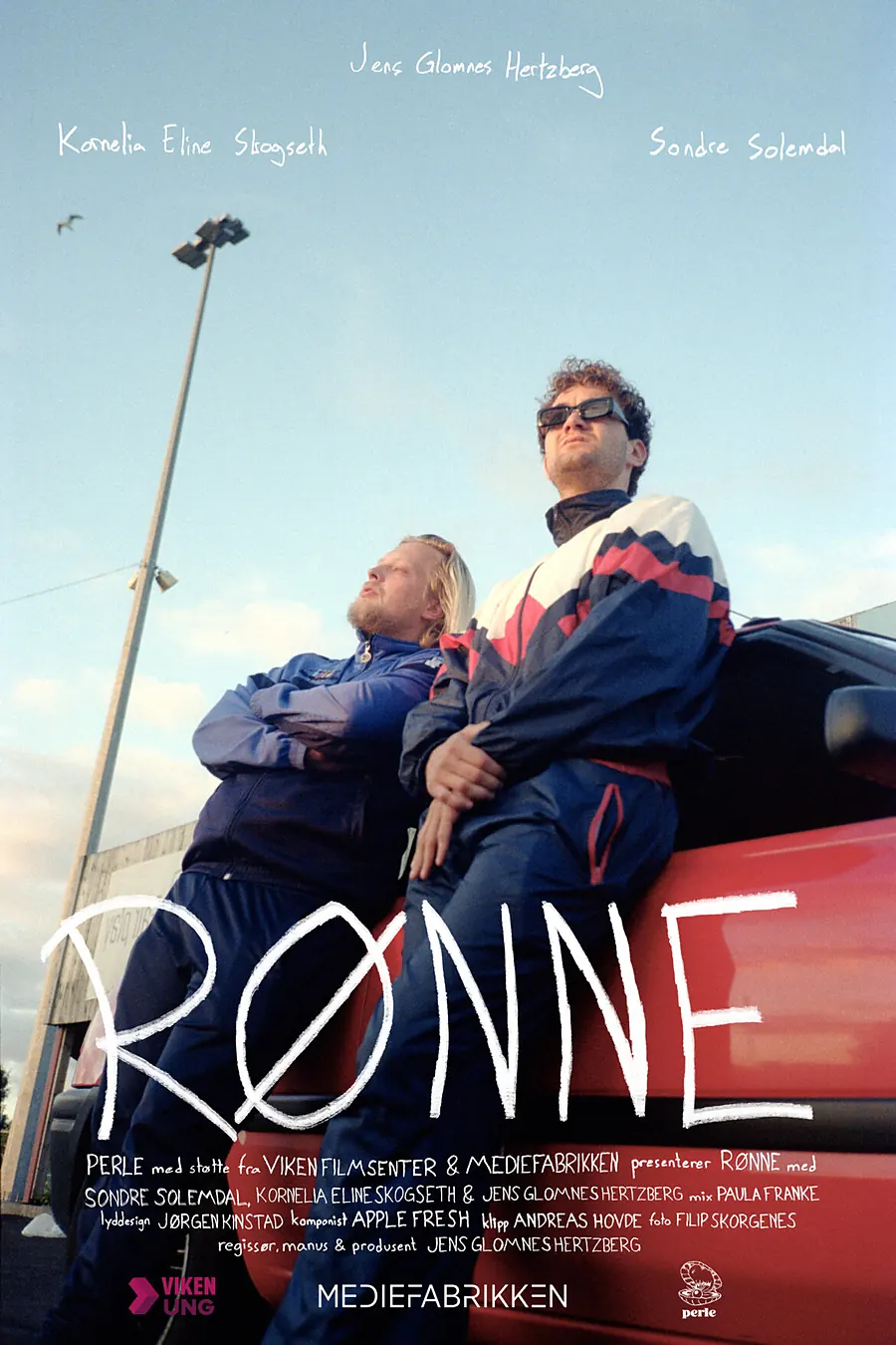Plakat for Rønne: to unge menn sitter på en rød bil under en blek himmel. Kreditten oppgir klipp Andreas Hovde.